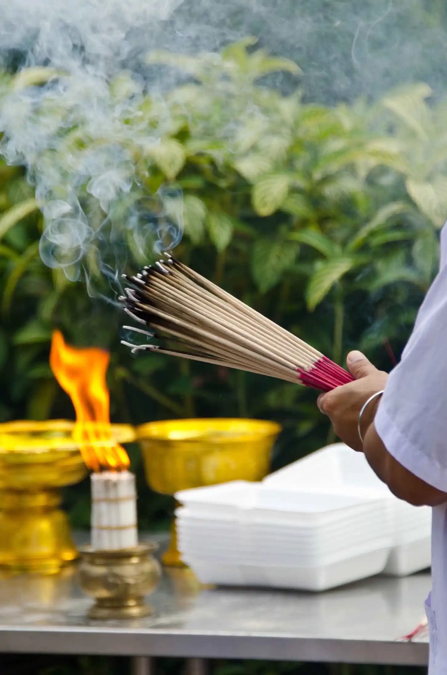 close-up-hand-holding-incense-sticks