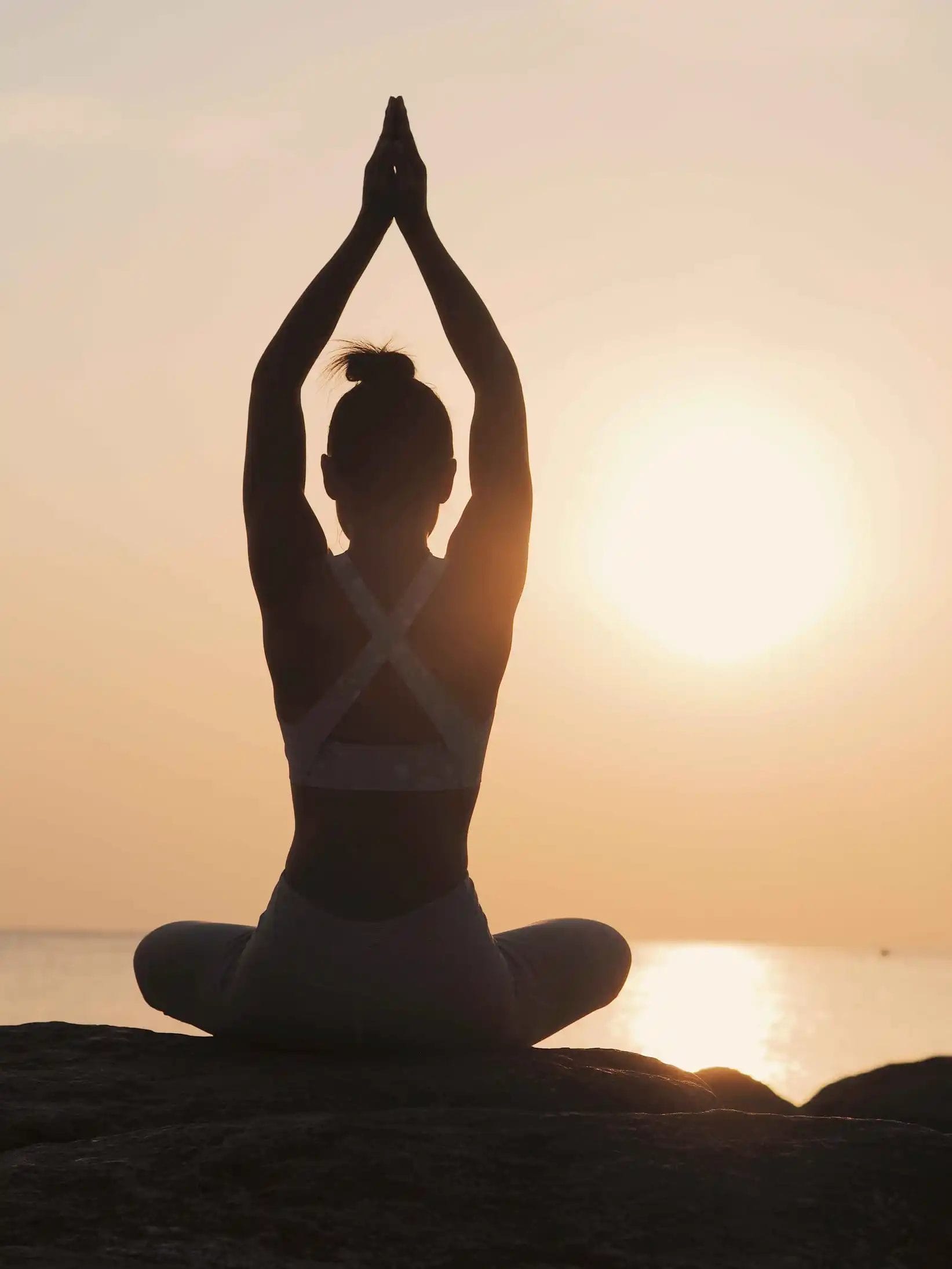 woman-practicing-yoga-beach-during-sunset